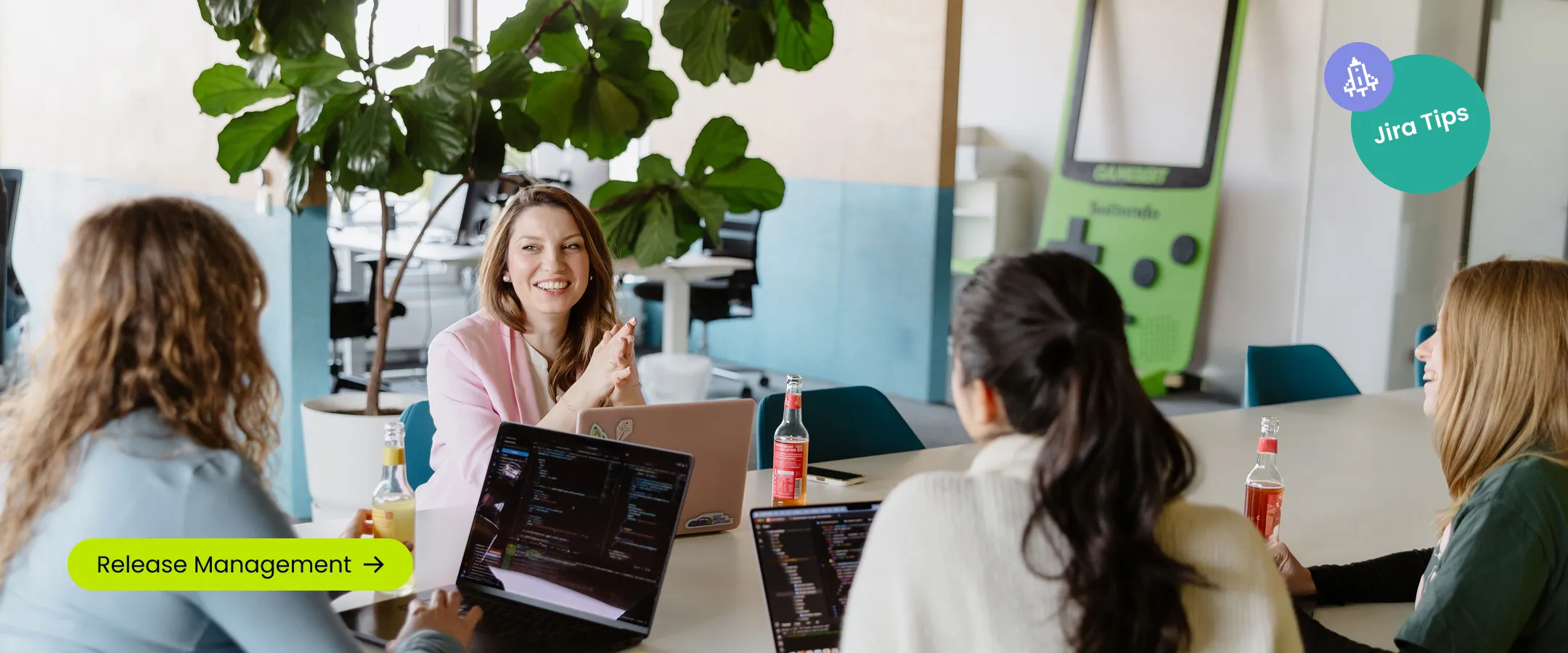 four people smiling and co-working with laptops