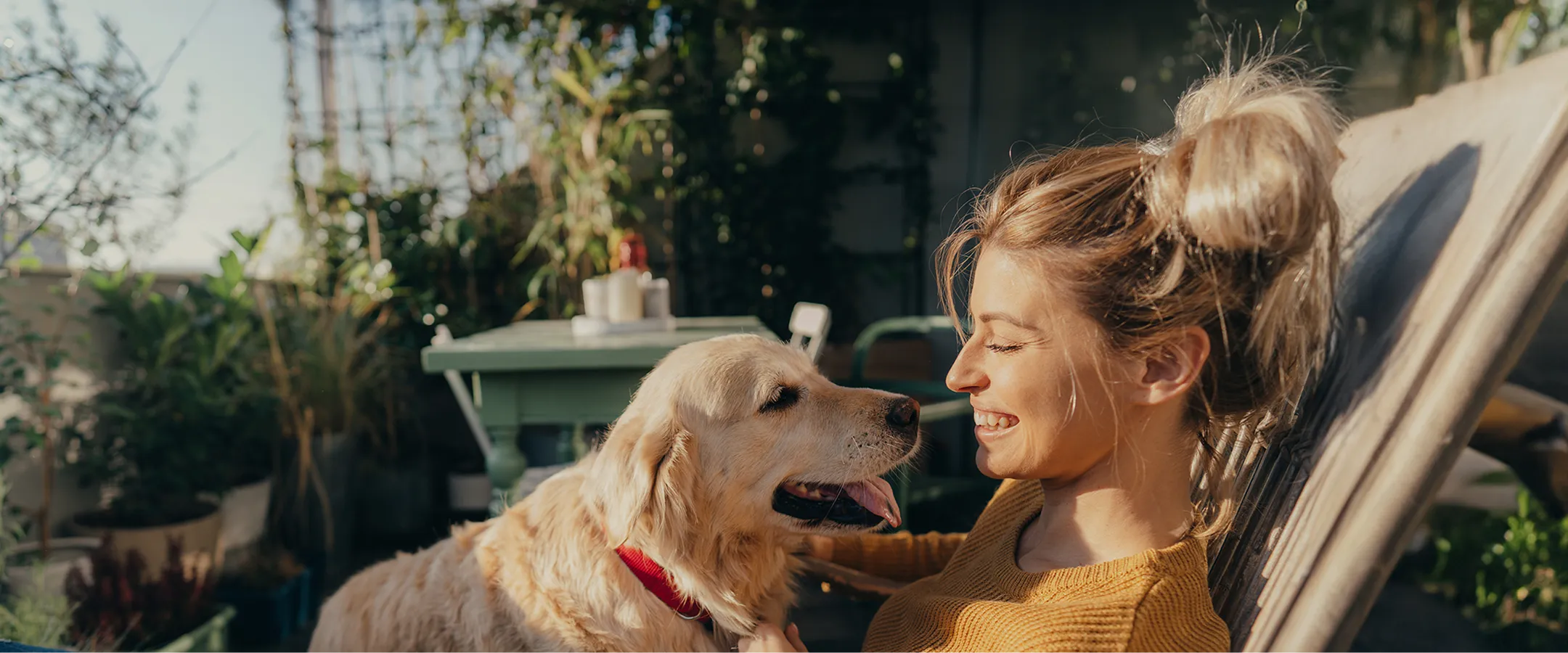 a woman smiling and petting a dog on her lap
