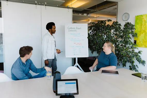 IT team reviewing a cloud migration project timeline on a whiteboard