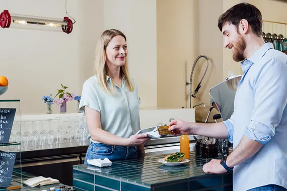 cashier accepting payment with a card reader