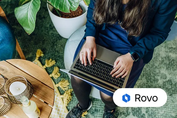 two people smiling and talking with a laptop