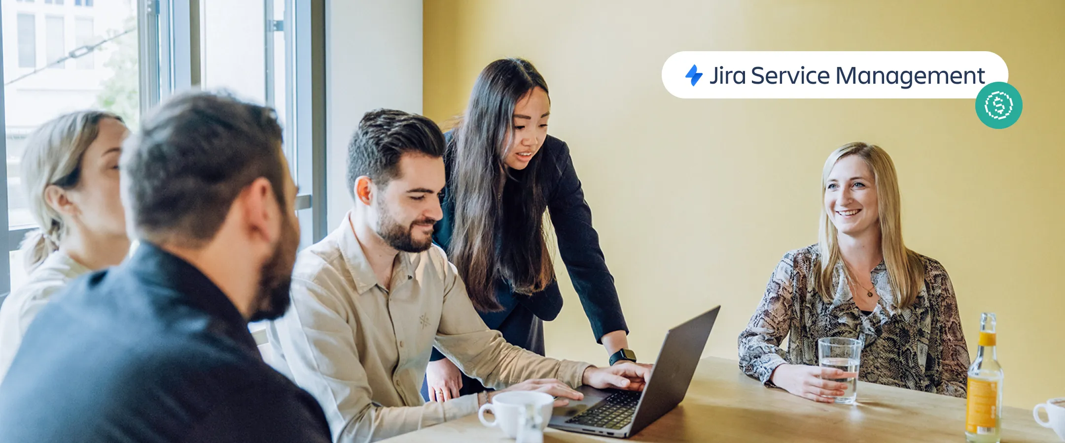 group of employees sitting at a table with the Jira Service Management logo in the foreground
