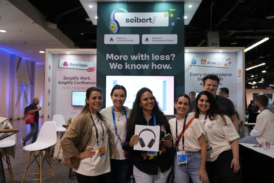 Seibert team members and a prize winner at the Seibert booth at Atlassian Team '26